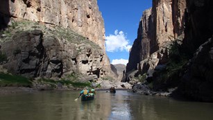 Canoes floating through a canyon