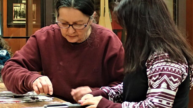 A cultural educator working with a child on an art project
