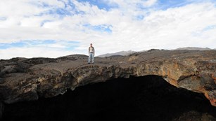 man standing on top of a cave