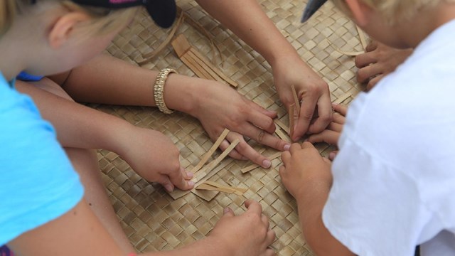 Kids learning to weave a Lauhala