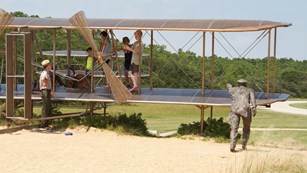 A ranger chats with children exploring a plane.