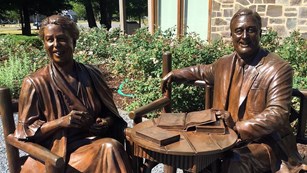 Statue of Eleanor Roosevelt and Franklin Roosevelt sitting at a table