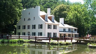 Large white house, which is a visitor center, next to the canal.
