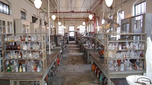 Rows of shelves filled with clear and colored glass bottles