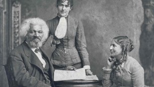 Black and white portrait of one man, two women