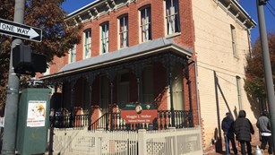 Two-story brick house with a porch and fence