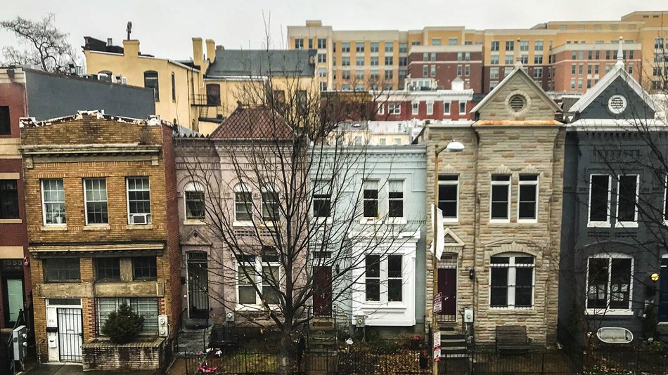 A row of townhouses in front of rows of modern buildings