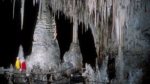 Two visitors looking at giant speleothems