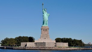 Statue of Liberty with hundreds of tourists at the base