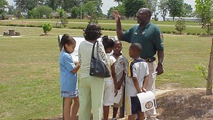 Volunteer talking to a family by an interpretive sign