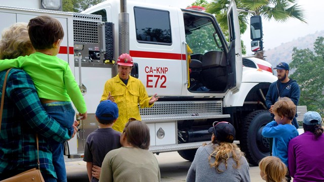 Kids talk to firefighters at a fire station.