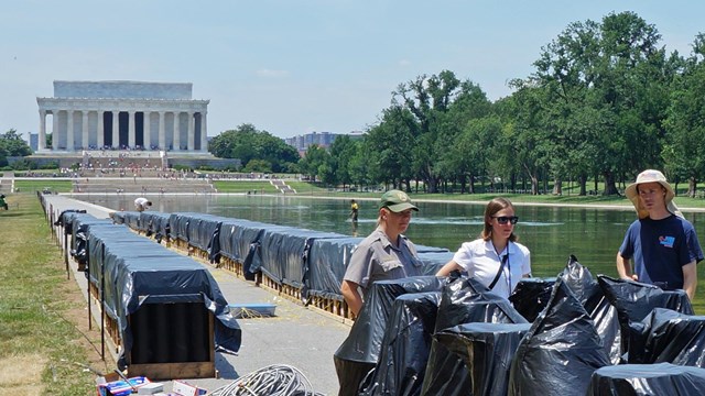Volunteers and interns assist Park Ranger in setting up an event at the National Mall