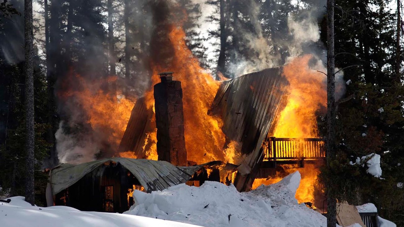 burning cabin in the woods in the winter