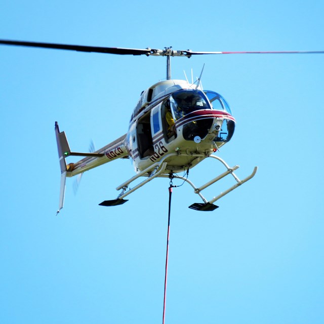 A helicopter brings in a sling-load of cargo.