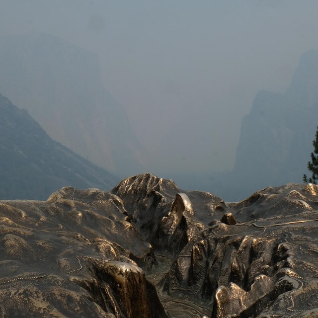 A model at an overlook shows the view obscured by smoke.