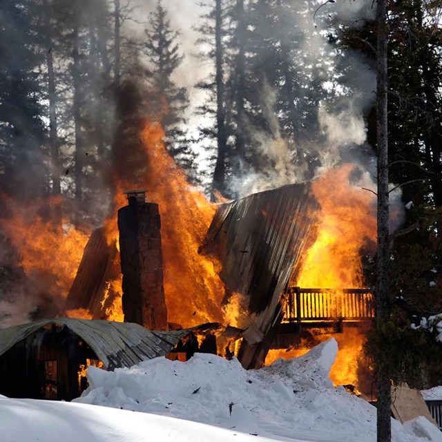 burning cabin in the woods in the winter