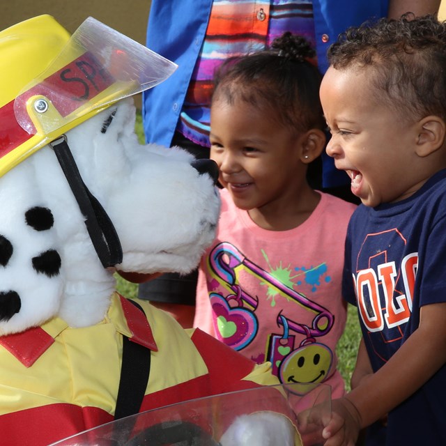 Sparky visits a child development center to share fire safety tips with young toddlers