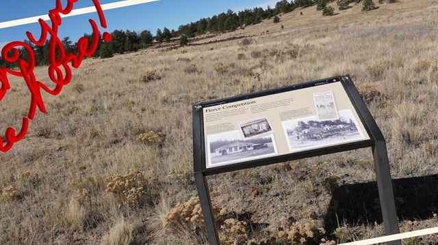 Wayside panel in front of a grassy valley view.