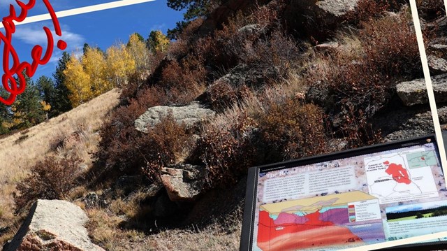 Photo of bile of boulders and a wayside panel at front.