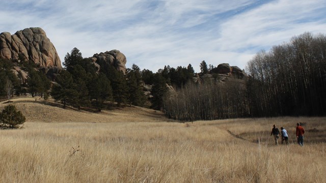 Hiker on trail approaching rock formation