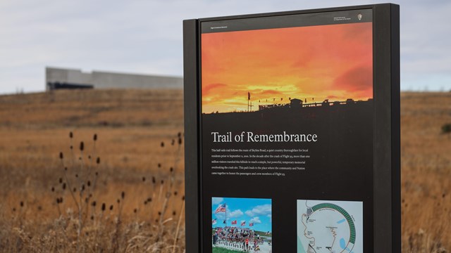 The Visitor Center sits in the background behind an informational panel