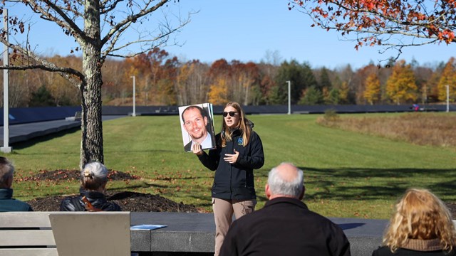 Intern giving a program to visitors about passengers of Flight 93. 
