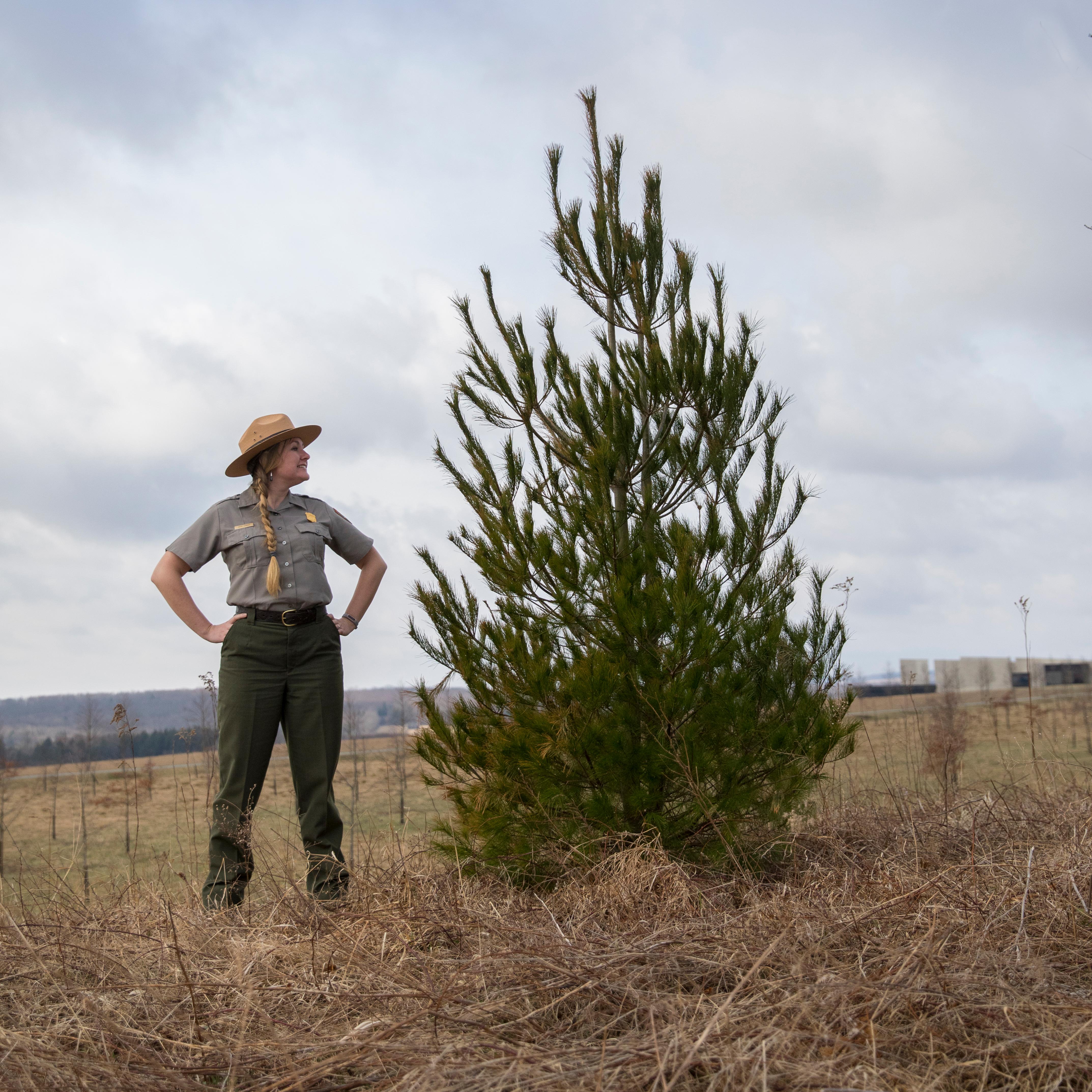 Park Ranger Katie standing next to a year.