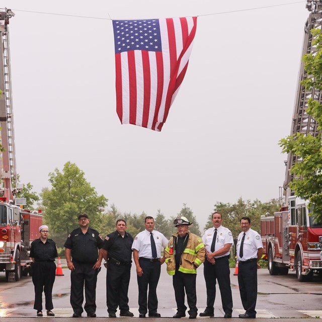 First responders posing under the American flag at the Wreckage Burial event at Flight 93.