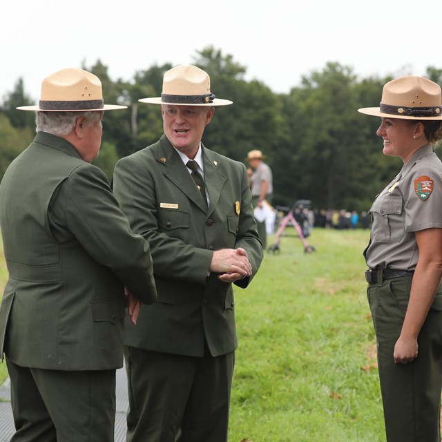 Park staff talking near the ceremonial Hemlock Gate and Crash Site 