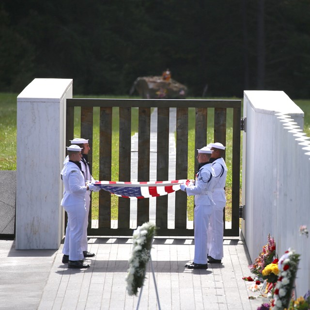 Sailors folding flag at Wall of Names