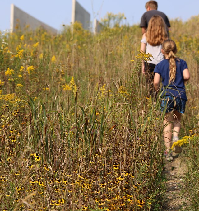 Children hiking up a steep hill towards the Visitor Center.