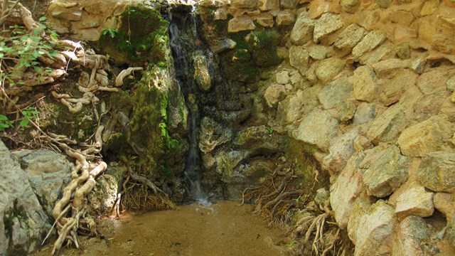 Water flows down a rock wall 