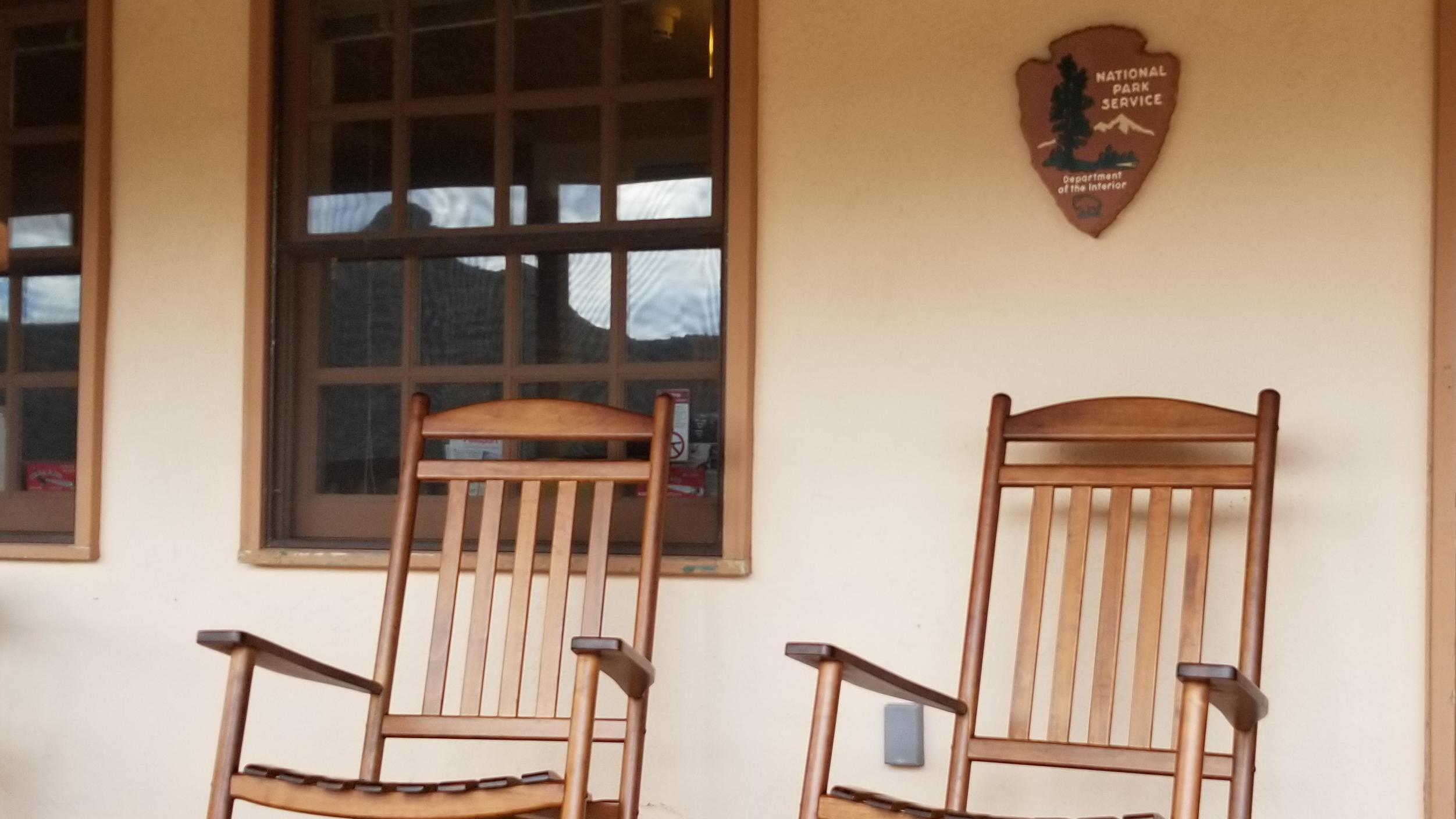 Rocking chairs with an arrowhead emblem above them.