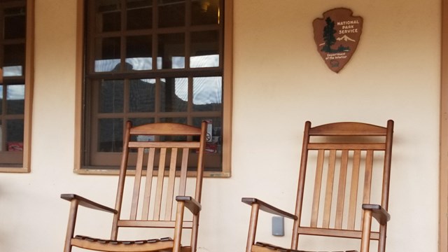 Rocking chairs with an arrowhead emblem above them.