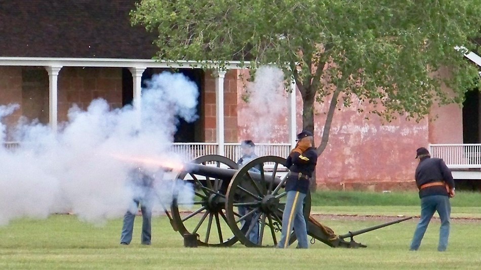 Artillery firing on the parade ground. Smoke billows from the 3 inch ordnance rifle.