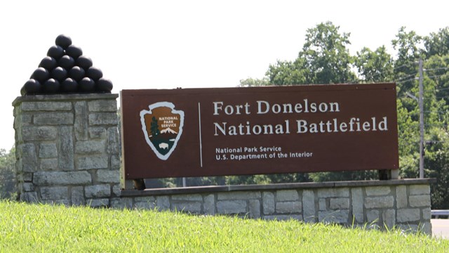 NPS entry sign to Fort Donelson National Battlefield with stacked cannonballs.  