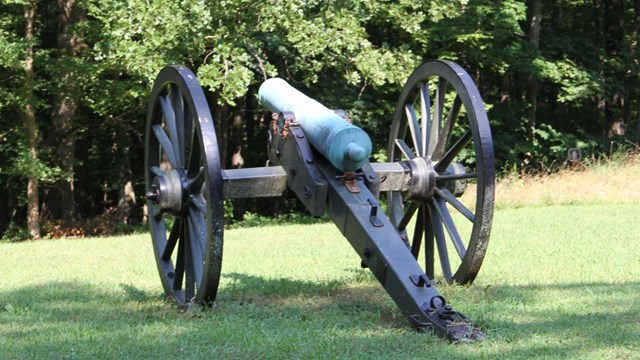 10lb bronze cannon facing a forrest