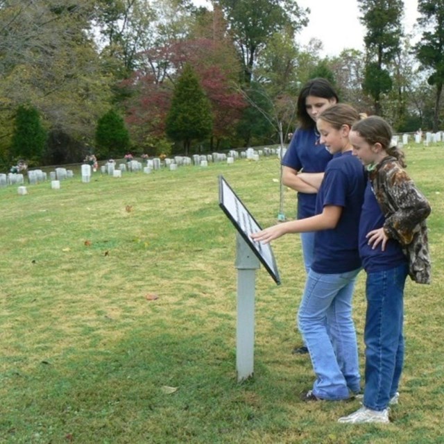 students reading an exhibit at the national cemetery