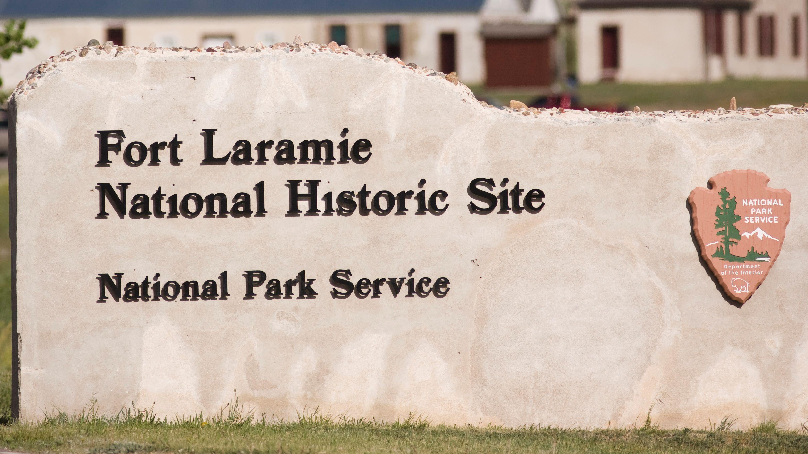 "Fort Laramie National Historic Site" sign positioned in a grassy area, indicating the historic loca