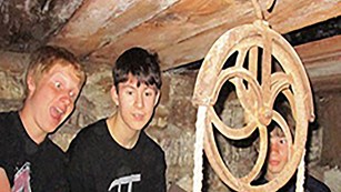 Young boys taking selfies around an underground well.