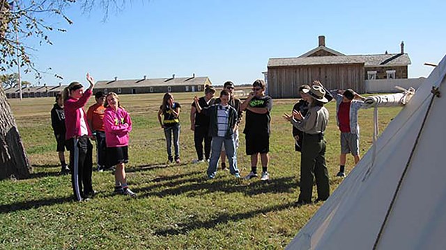 Ranger talking to HS students by a tipi.