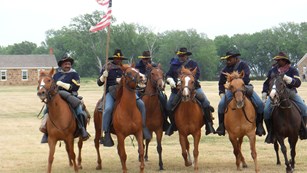 Image of men on horseback in 19th century U.S. Army cavalry uniforms.