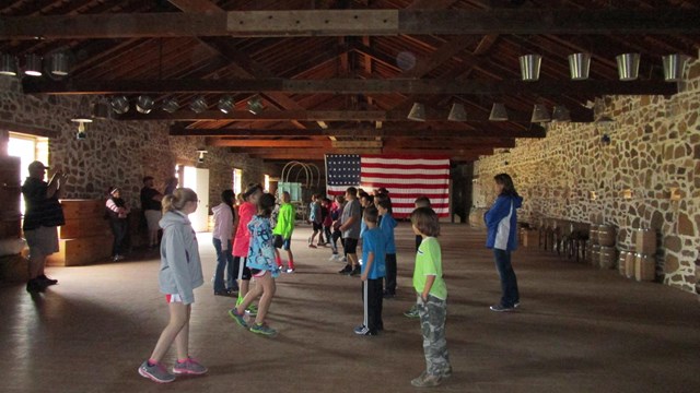 Elementary age children dancing in a warehouse.
