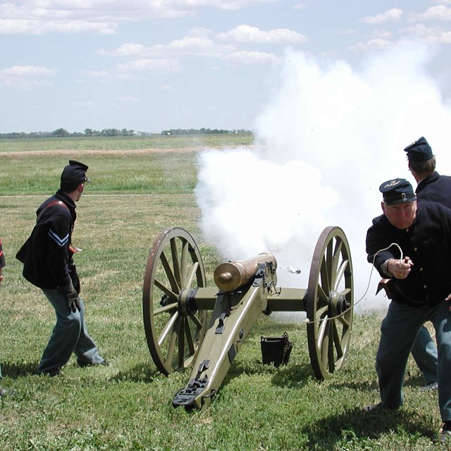 Re-enactors firing a cannon.