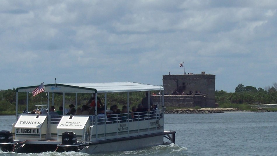 Profile of Fort Matanzas National Monument. Grass in front and cloudy sky in background.