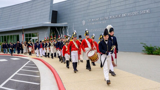 Living History marching to a bus in the parking lot at Fort McHenry.