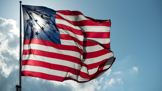 Star-Spangled Banner garrison flag flying above the fort.