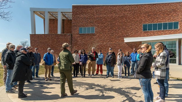 A ranger talking to a group of visitors behind the visitor center.