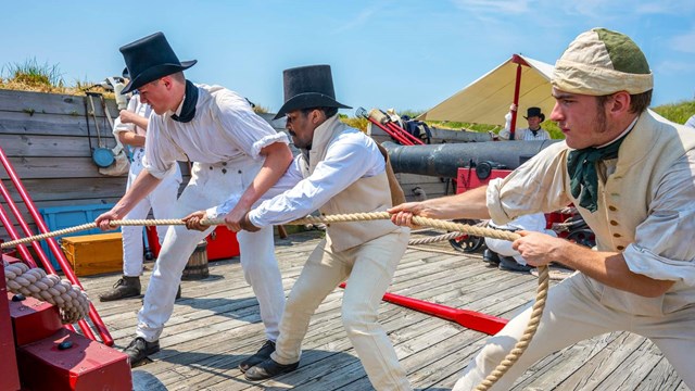 Three Fort McHenry Guard members during a cannon demonstration