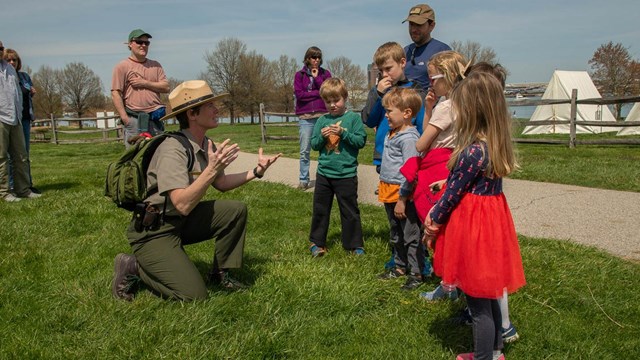 A ranger talking to a group of children.